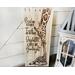 Giraffe nursery wall decor. A giraffe mother kisses a baby giraffe's head. The artwork is drawn using pyrography tools onto reclaimed wood.